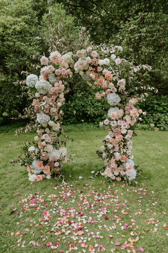 a lovely summer wedding arch with blush, peachy and white dahlias, roses and hydrangeas is a cool and pretty idea