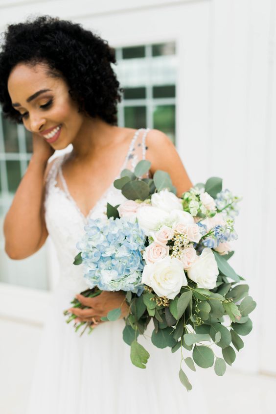 a lovely wedding bouquet with blue hydrangeas, white and blush roses, some waxflowers and greenery for summer or spring