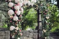 a lush wedding arch covered with lush florals on one side and with greenery for a spring feeling