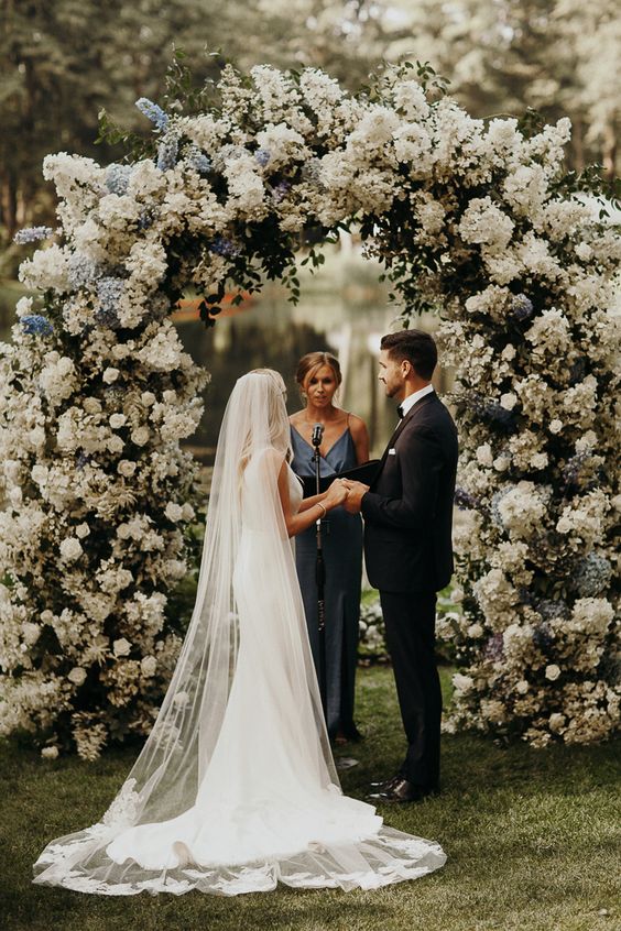 a lush wedding arch styled with greenery, white and blue blooms is a fantastic idea that wows, it will have a big impact on the space