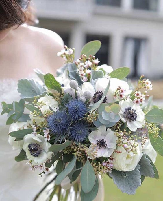 a lush wedding bouquet of white anemones, thistles, greenery, berries and pale leaves is a lovely idea for a wedding