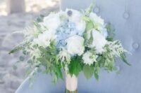 a nautical wedding bouquet of white roses, blue hydrangeas, thistles, astilbe and greenery is a beautiful idea