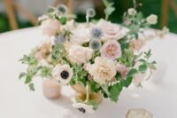 a neutral wedding centerpiece of white roses and anemones, neutral carnations, blush peony roses, greenery and allium