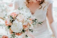 a pastel and neutral wedding bouquet of white peonies, blush peony roses and peachy carnations, greenery and white fillers plus ribbons