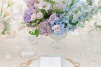 a pastel wedding centerpiece of blue hydrangeas, lilac roses, hydrangeas and sweet peas is a great idea for spring