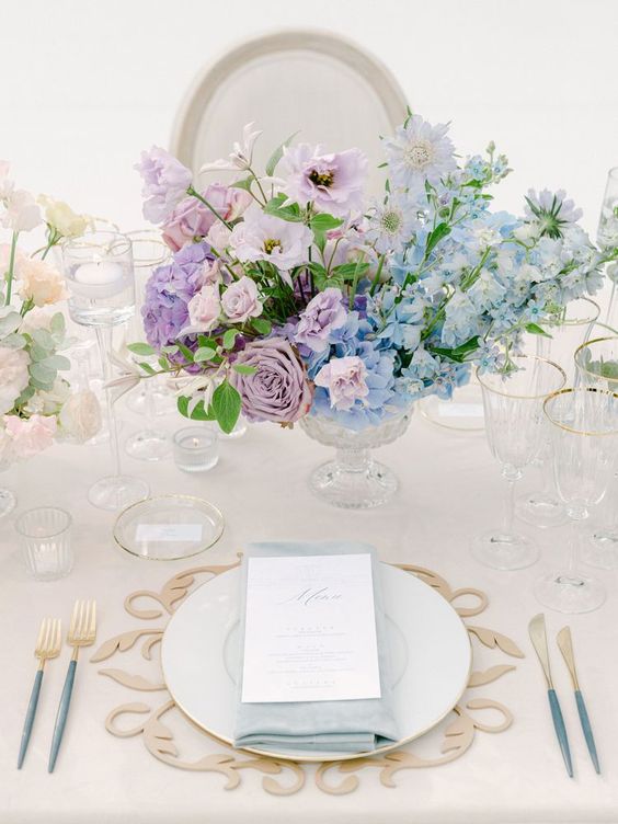 a pastel wedding centerpiece of blue hydrangeas, lilac roses, hydrangeas and sweet peas is a great idea for spring