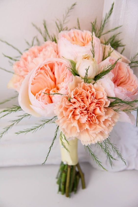a peachy wedding bouquet of carnations and peony roses plus some greenery is a very cool and bright idea for spring or summer