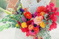 a pretty and bright wedding bouquet with red, blush, yellow and orange blooms, greenery and fillers that add dimension