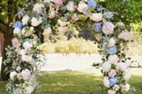 a pretty spring and summer wedding arch done with greenery, white, blush and blue hydrangeas is a gorgeous idea