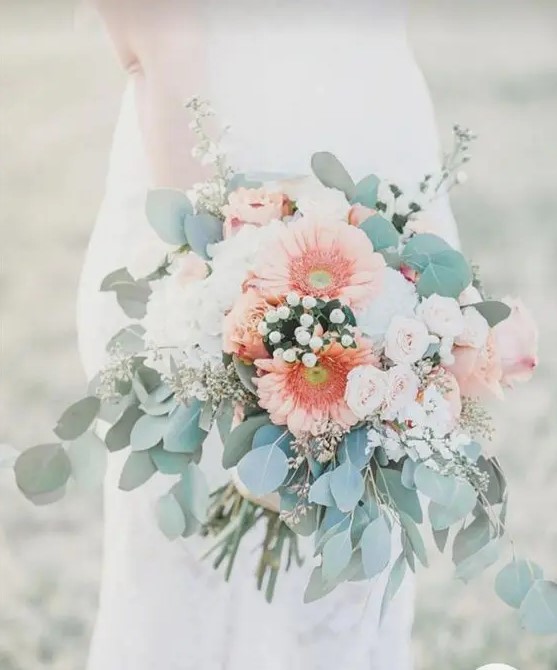 a pretty wedding bouquet of white hydrangeas, blush garden roses and coral gerberas plus greenery and berries
