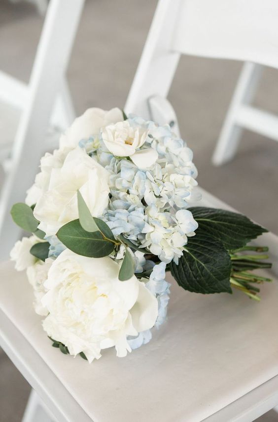 a pretty wedding bouquet of white peonies and blue hydrangeas and leaves is a stylish idea for a spring or summer wedding
