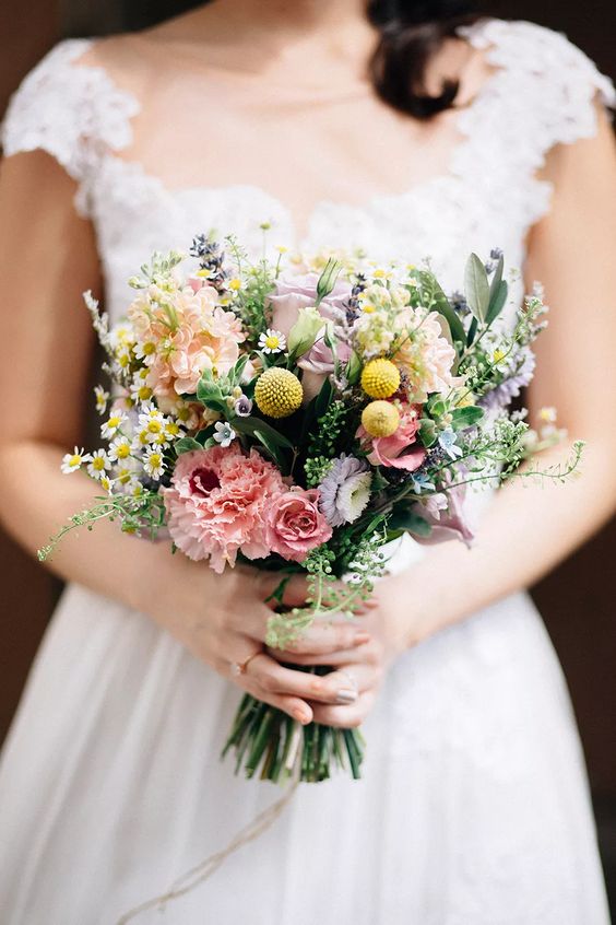 a pretty wildflower wedding bouquet of blush roses, carnations, billy balls, grasses, lavender and greenery