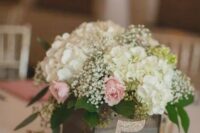 a reclaimed wooden box with baby’s breath, hydrangeas and roses, a glitter table number for a rustic wedding centerpiece