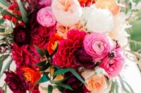 a refined and bold wedding bouquet with red, purple, pink, blush and yellow blooms and some greenery and berries