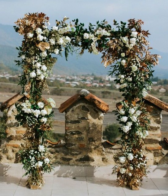 a refined wedding arch done with greenery, white blooms and dried bold foliage is a stylish idea for a fall wedding