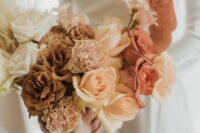a refined wedding bouquet of white, coffee-colored and rust and peachy roses, blush carnations and neutral ribbons is fantastic