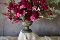 a refined wedding centerpiece of pink carnations and burgundy peonies plus greenery is a catchy idea for a wedding