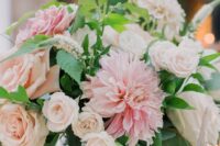a romantic pink and blush wedding centerpiece of roses and dahlias and greenery for a spring or summer wedding