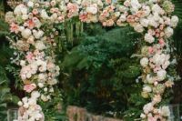 a romantic wedding arch decorated with white hydrangeas, pink roses and peony roses, greenery, twigs and branches