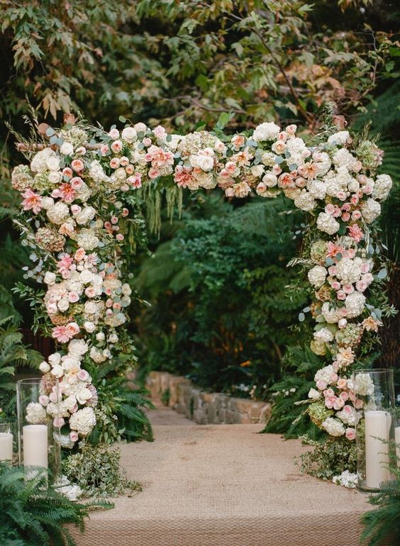 a romantic wedding arch decorated with white hydrangeas, pink roses and peony roses, greenery, twigs and branches