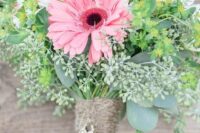 a rustic wedding bouquet of pink roses, gerberas, white fillers and greenery for a spring or summer wedding