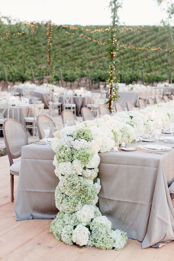 a simple and cool lush wedding table runner of green and white hydrangeas is a beautiful idea for spring and summer