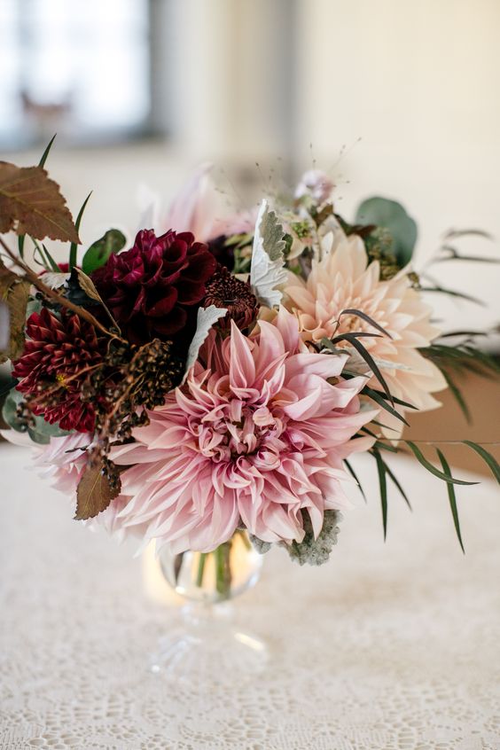a simple and cool wedding centerpiece of blush, pink, burgundy blooms, leaves and berries is a cool idea for a fall wedding