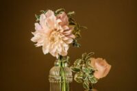 a simple and elegant cluster wedding centerpiece of a blush dahlia and rose and some candles is a lvoely solution