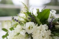 a simple and lovely wedding centerpiece of white roses and hydrangeas, lavender and leaves is a cool idea for spring or summer