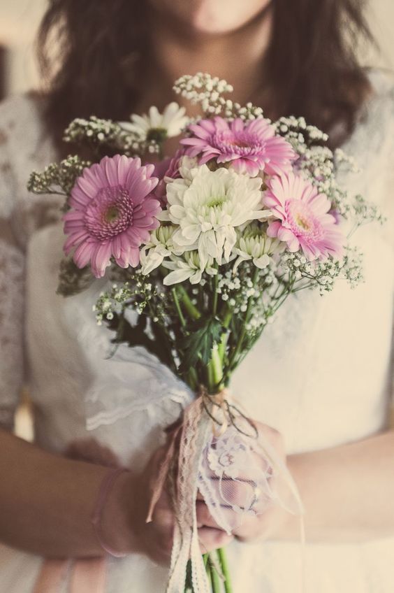 a simple and pretty wedding bouquet of pink gerberas, white mums, baby's breath and a delicate lace and twine wrap