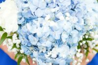 a simple and stylish wedding bouquet of blue hydrangeas, white roses and baby’s breath is a cool idea for spring or summer