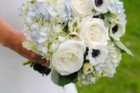 a spring or summer wedding bouquet of blue hydrangeas, white roses and anemones plus leaves is cool
