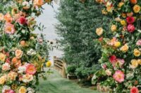 a stunning wedding arch covered with greenery, white, blush and yellow roses and coral peonies is a gorgeous idea