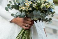 a stylish wedding bouquet of blue hydrangeas, chamomiles, thistles, eucalyptus is a catchy and chic idea for a modern bride