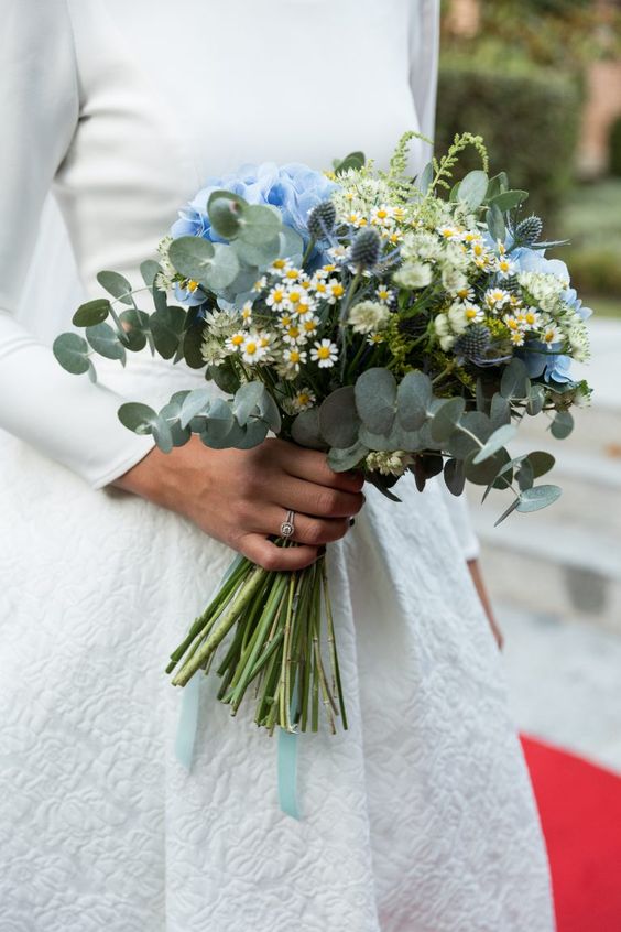 a stylish wedding bouquet of blue hydrangeas, chamomiles, thistles, eucalyptus is a catchy and chic idea for a modern bride