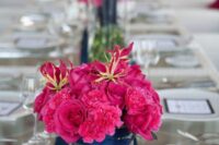 a super bold magenta wedding centerpiece of roses and carnations and some greenery is a cool idea for a wedding