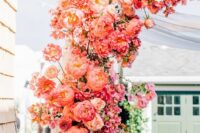 a super bold wedding arch with coral peonies and dahlias, some roses is a fantastic idea for a summer wedding