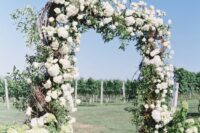 a super lush rustic wedding arch decorated with twigs, greenery branches and white hydrangeas is a beautiful and stylish idea