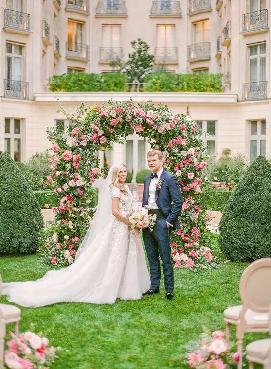 a super lush wedding arch done with greenery, with blush and hot pink roses and dahlias looks very beautiful and perfectly matches the location