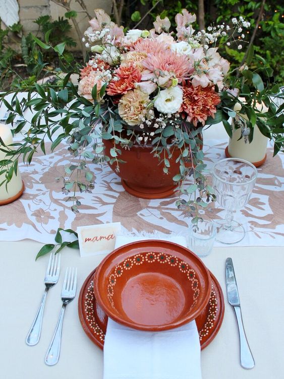 a textural wedding centerpiece of blush, pink, neutral blooms including dahlias and carnations, baby's breath and greenery