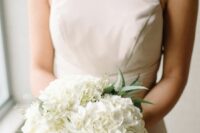 a timeless white hydrangea wedding bouquet with a bit of greenery is a stylish idea for a modern bride, whatever the season is