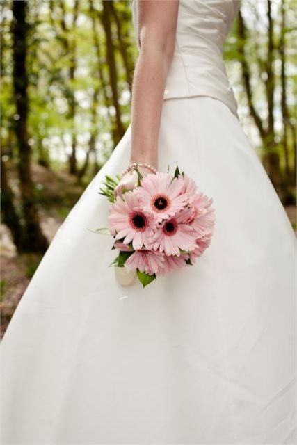 a tiny pink gerbera wedding bouquet with leaves is a pretty idea and small wedding bouquets are extremely popular now