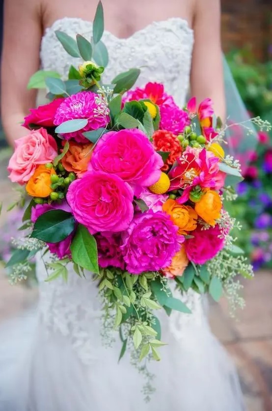 a vibrant wedding bouquet with hot pink, light pink, honey yellow, billy balls, greenery is a cool and bold idea