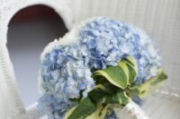 a wedding bouquet of blue hydrangeas and white roses and some leaves is a lovely solution for your something blue