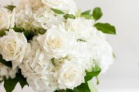 a white hydrangea and rose wedding centerpiece with leaves is a stylish idea for a chic and classic wedding