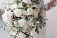 a white winter wedding bouquet with roses, hydrangeas, berries, pinecones and pale greenery