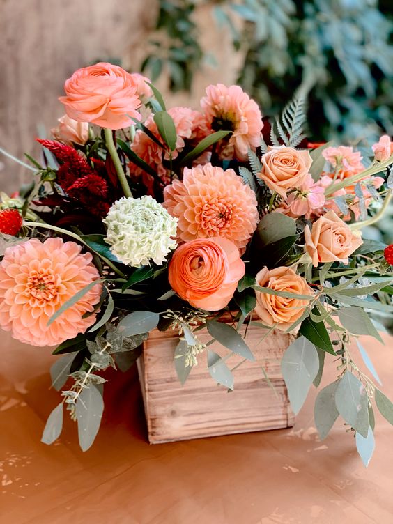 an amazing wedding centerpiece of peachy dahlias and roses and aranunculus, greenery and lisianthus is wow