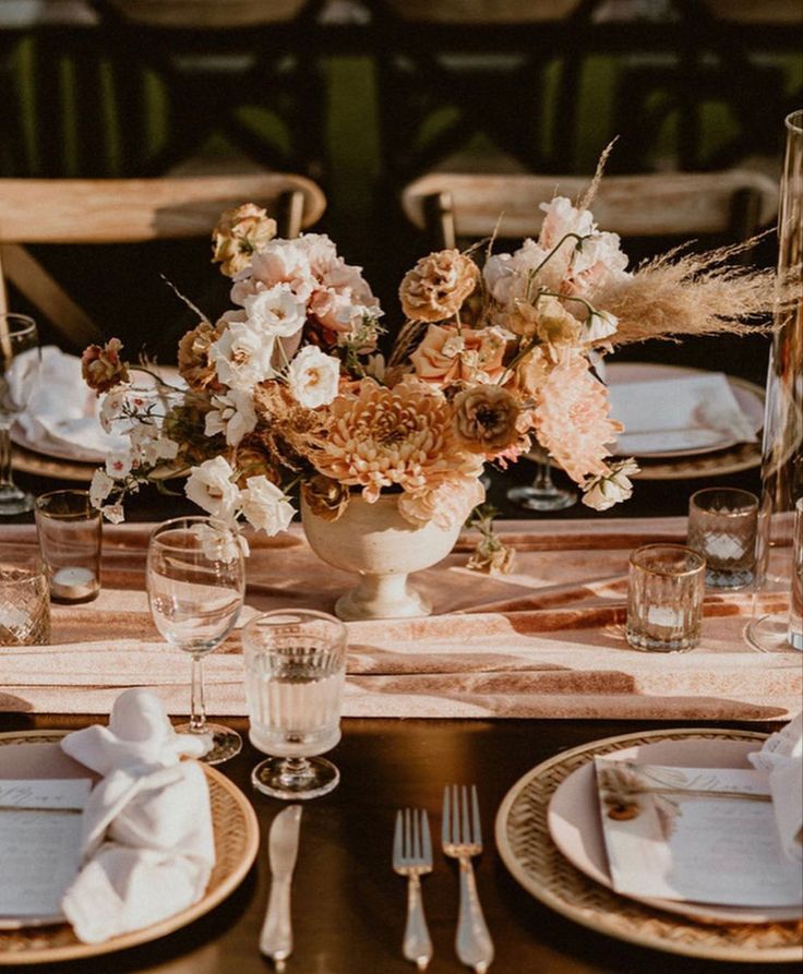 an earthy-tone wedding centerpiece of coffee-colored carnations and dahlias, white blooms and blush mums, pampas grass is a cool idea
