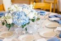 an elegant wedding centerpiece of blue and white hydrangeas and white roses is a stylish idea for spring and summer
