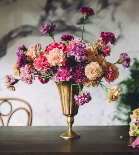 an eye-catching wedding centerpiece of a gold vase with blush, pink and purple carnations is a lovely idea for a bold wedding